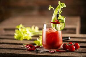 Classic bloody mary or virgin mary vodka cocktail in a cup with as a hangover drink in a rustic envrionment photo