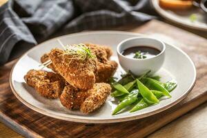 Fried chicken wings with sugar peas and herbs photo