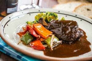 confitar Conejo pierna con vegetal un pan vid roja en pub o restaurante foto