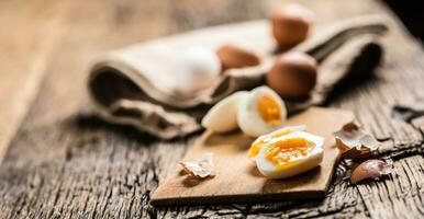 Close-up boiled or raw chicken eggs on wooden board photo