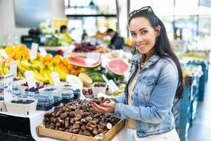 Beautiful woman holds handful of chestnuts in the farmers market photo