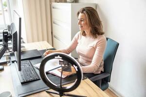 Accountant working with a desktop computer at office. A businesswoman gives an online interview with her client photo