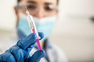 A SARS Cov-2 vaccine in syringe ready to apply vaccination into a patient by a medical staff photo