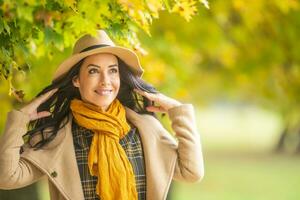 de moda hembra modelo usa sombrero, chaqueta y bufanda en un otoño día al aire libre foto