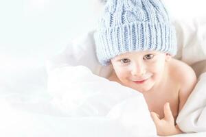 Habby young smilling child boy in white bed photo