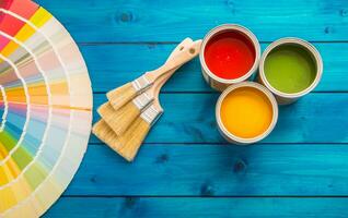 pintar latas color paleta, latas abrió con cepillos en azul mesa foto