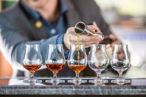 Bartender professional preparing five alcololic drinks. photo