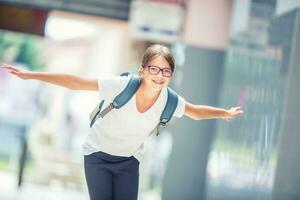 Schoolgirl with bag, backpack. Portrait of modern happy teen school girl with bag backpack. Girl with dental braces and glasses photo