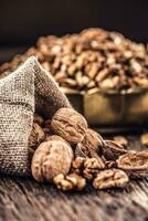 Walnut kernels whole walnuts in burlap sack and vintage bowl photo
