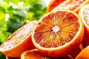 Blood sicilian oranges sliced with fresh melissa - close up photo