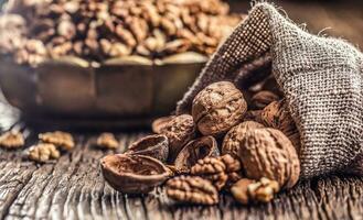 Walnut kernels whole walnuts in burlap sack and vintage bowl photo