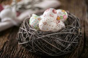 Pascua de Resurrección huevos en un de madera nido, mano pintado foto