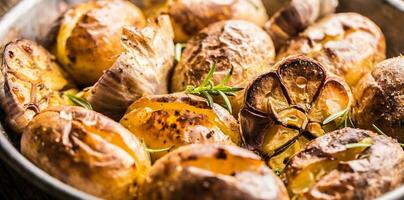 Potatoes roasted with garlic spices and herbs in vintage pan photo