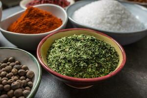 Dried parsley and variety spices and herbs in bowls photo