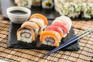 conjunto de rodar Sushi oro California con palillos y soja salsa. foto