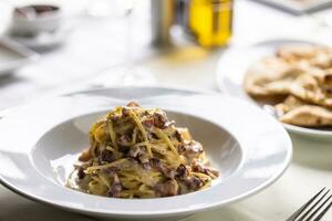 Spaghetti carbonara with eggs, bacon and generous pinch of black pepper photo