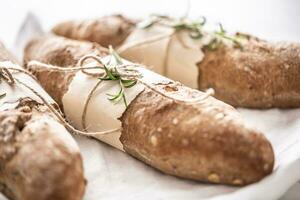 Detail of fresh crusty wholegrain breads on a white surface photo