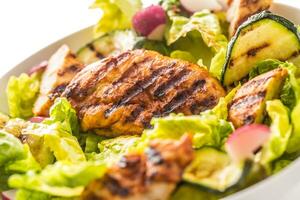 Chicken breast. Grill chicken breast with lettuce salad zucchini and radish isolated on white photo