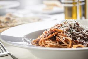 detalle de espaguetis con tomate salsa, albahaca, y parmesano en parte superior foto