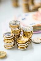 Euro banknotes and coins togetger on white table - close-up photo