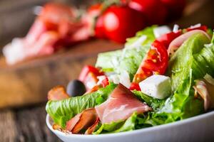 Salad. Fresh summer lettuce salad.Healthy mediterranean salad olives tomatoes parmesan cheese and prosciutto. photo