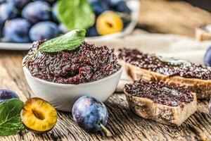 Breakfast from homemade plum jam bread and ripe plums. photo