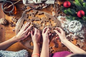 Gingerbread dough and young girls hands preparing christmas biscuit cakes photo