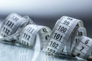 Curved measuring tape. Measuring tape of the tailor. Closeup view of white measuring tape photo