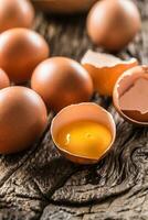 Fresh raw eggs on rustic wooden table photo