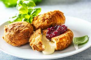 Fried camembert or brie cheese with cranberry jam and basil photo