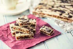 A waffle cake with caramel chocolate and walnuts.Traditional slovak and czech cake grilaz with coffee photo