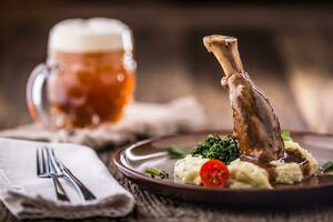 Lamb shank.Confit lamb shank with mashed potatoes spinach and draft beer in pub or restaurant photo