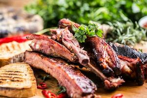 Tasty barbecue grilled pork ribs with chili pepers and parsley herbs. photo