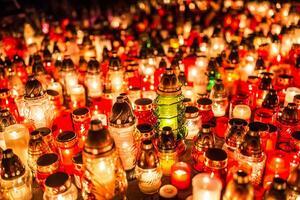 muchos ardiente velas en el cementerio a noche en el ocasión almas de el fallecido foto