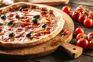 Pizza diavola traditional italian meal with spicy salami peperoni chili and olives photo