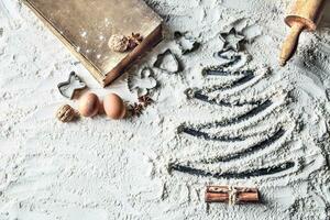 Shaped christmas tree of flour and old recipe book. photo