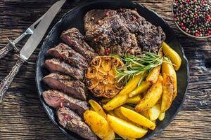 Grilled beef Rib Eye steak with garlic american potatoes rosemary salt and spices photo