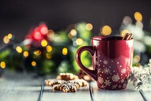 Christmas punch in a red cup with gingerbread cinnamon and holiday decorations photo