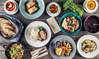 Top view of assortment of food served on a rustic wooden table photo