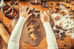 Gingerbread dough and woman hands preparing christmas biscuit cakes photo