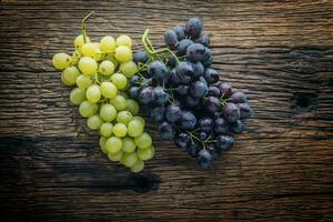 Grape. Bunch of multicolored grapes on rustic wooden table photo