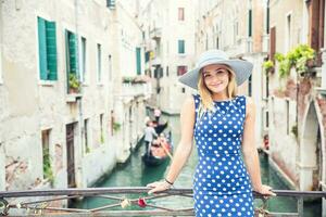 Happy young attractive woman fashion model of venice italy in blue polka dot outfit photo