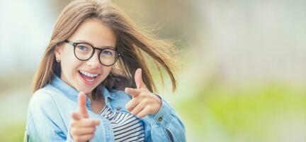 Portrait of happy smilling teenage young girl with glasses and b photo