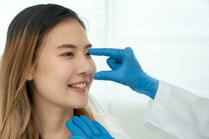 plastic surgery, beauty, Surgeon or beautician touching woman face, surgical procedure that involve altering shape of nose, doctor examines patient nose before rhinoplasty, medical assistance, health photo