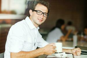 un hombre en lentes participación un taza de café foto