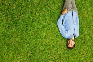 a man laying on the grass with his legs up photo