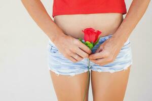 a woman in shorts holding a red rose photo