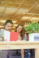 a man and woman sitting at a table looking at a book photo