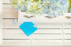 a white wooden table with blue flowers and a note photo