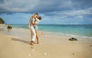 a man and woman are hugging on the beach photo
